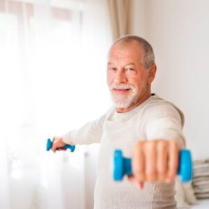 A senior using free weights at home