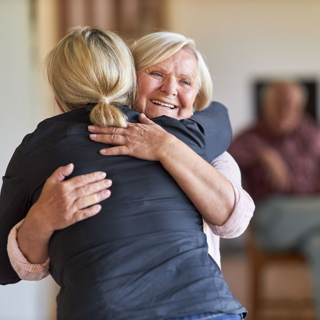 daughter hugging her elderly mother