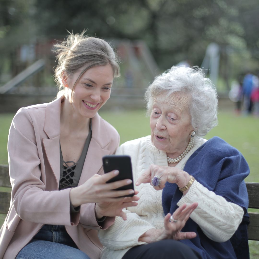 woman showing her elderly relative her phone