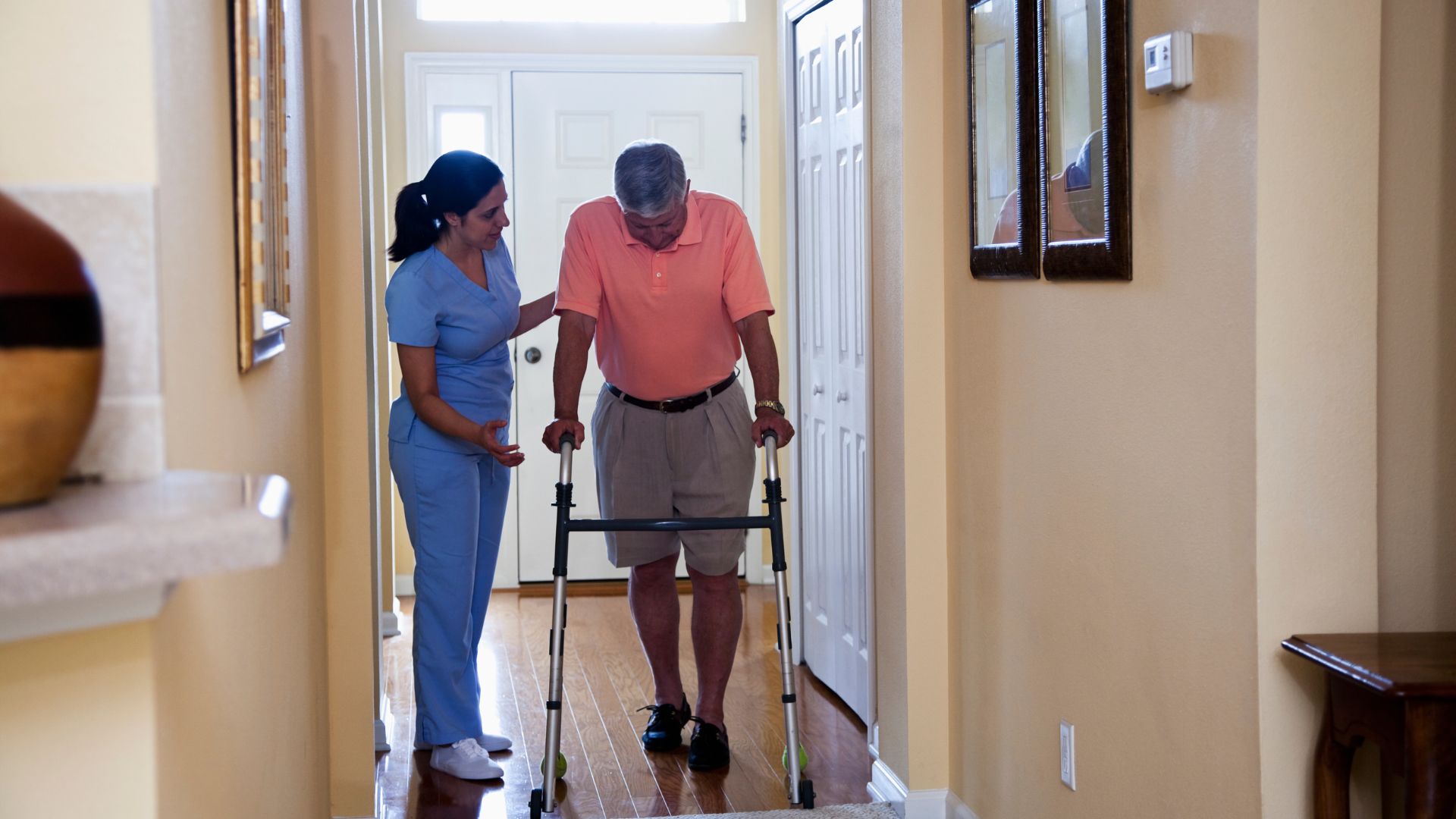 Nurse helping a patient walk through the walkers with a walker.