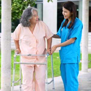nurse helping a person with a walker