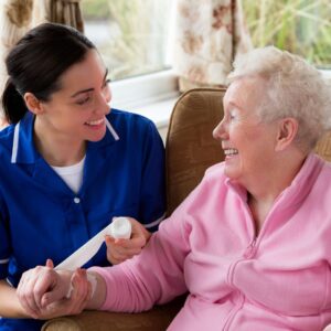 Nurse sitting next to the person she is helping
